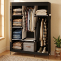 Black portable fabric closet in a bedroom with shirts, coats and folded clothes
